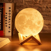 Warm moon lamp glowing beside books